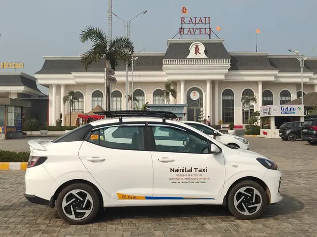 White Hyundai Aura sedan with Nainital Taxi branding, side view